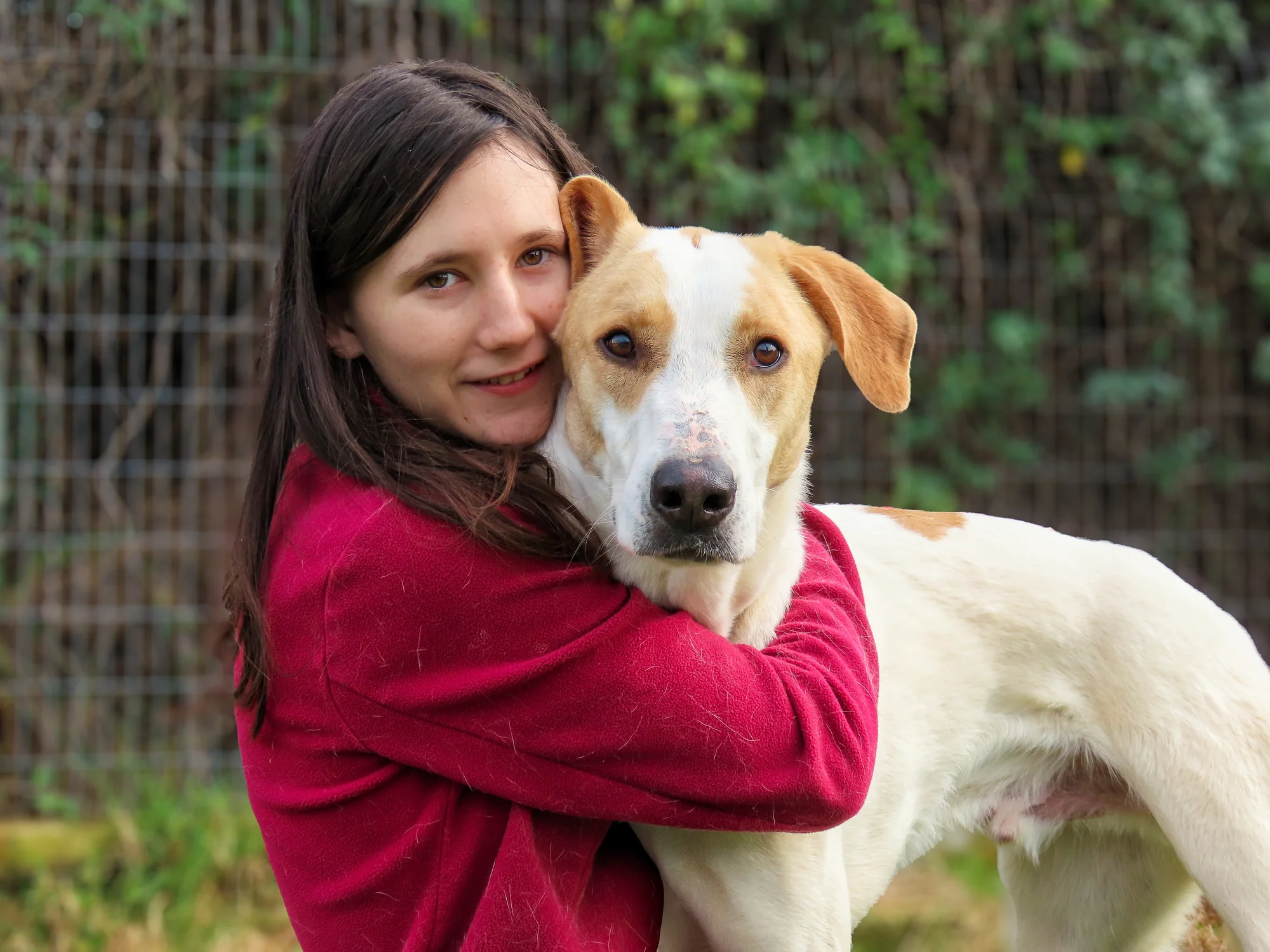 A young person embracing a dog at Eshbal